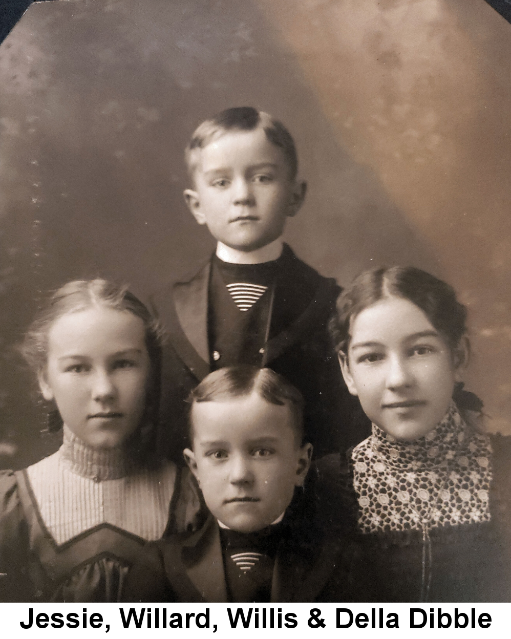 IMAGE/PHOTO: Jessie, Willard, Willis & Della Dibble: Black and white photo of four children: two boys in identical shirts, jackets and vests, one standing behind the other, flanked by a blond girl on the left and brunette girl on the right.
